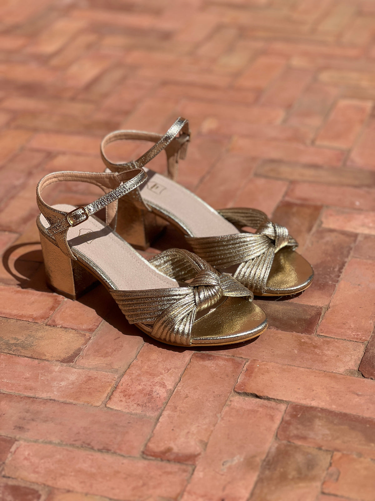 Sandalias de tacón en piel dorada de Sira Montero